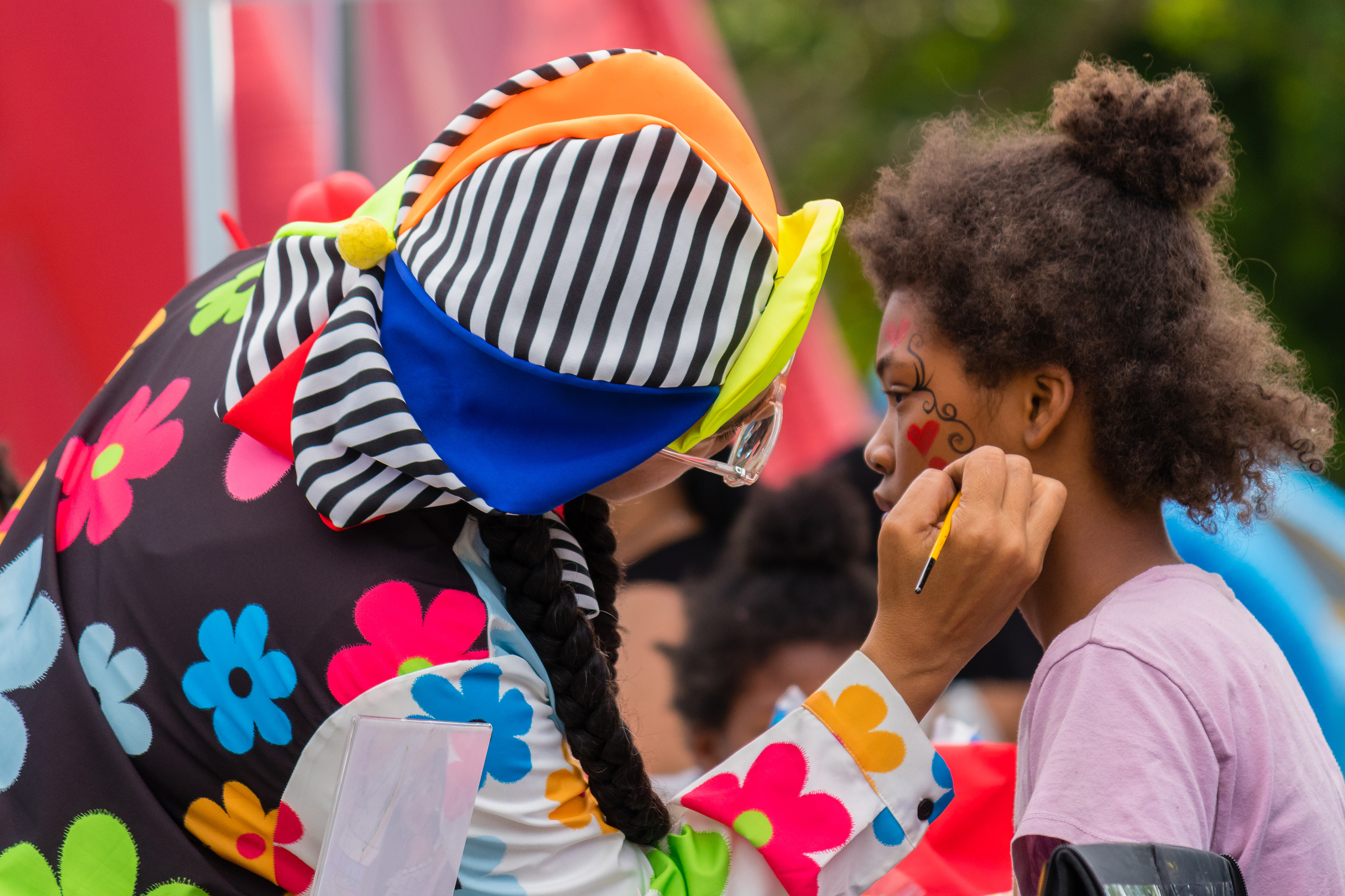 A child getting her face painted at a neighborhood event.