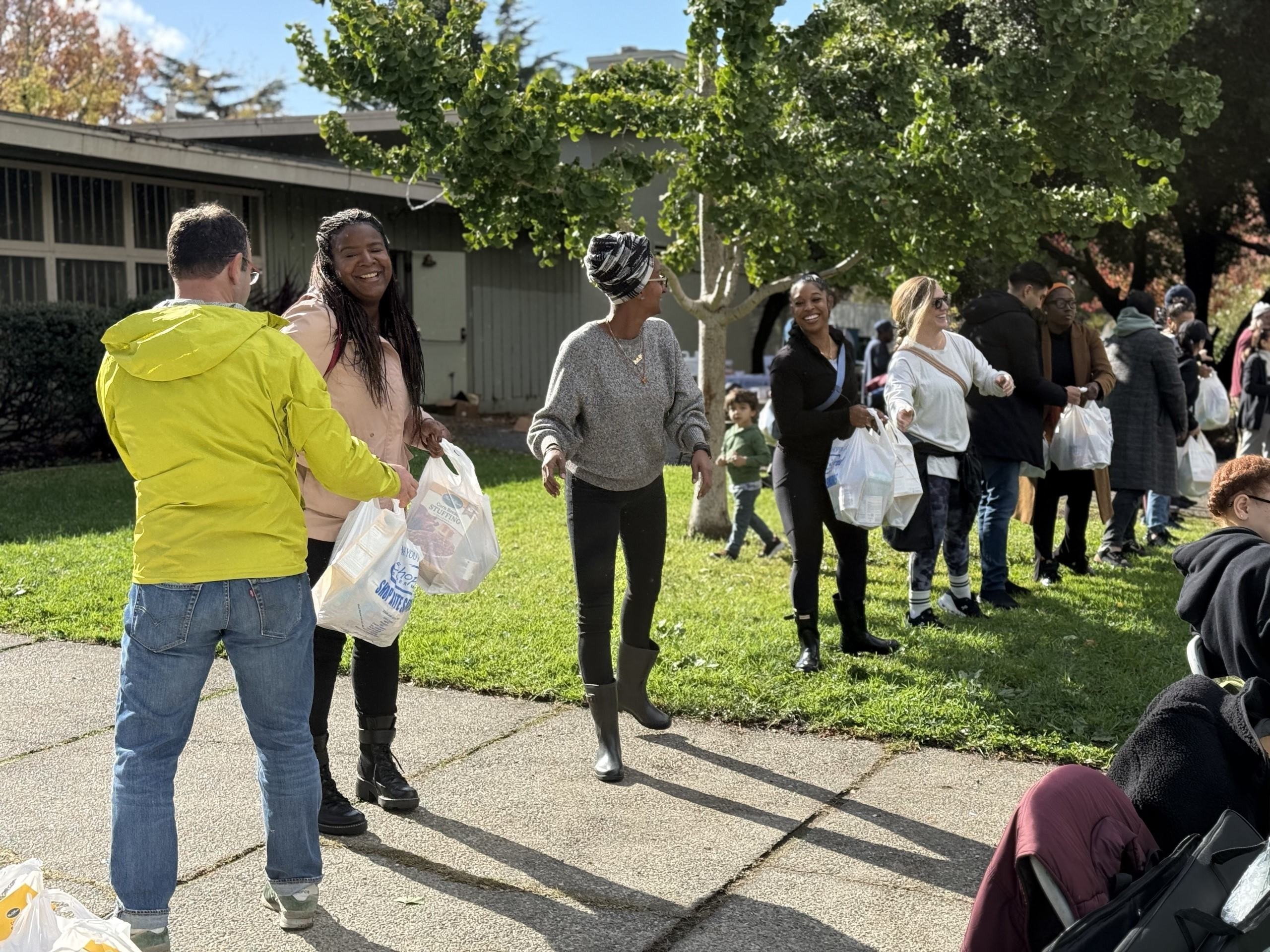 OHA staff and volunteers hand out holiday meal bags at the District 6 Thanksgiving Food Giveaway.