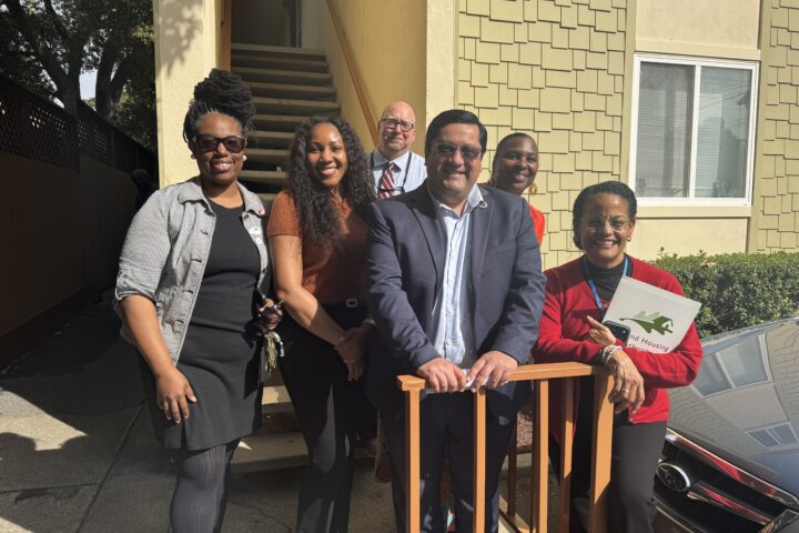 Sen. Jesse Arreguín and Oakland Housing Authority staff pose outside an affordable housing community in Oakland.