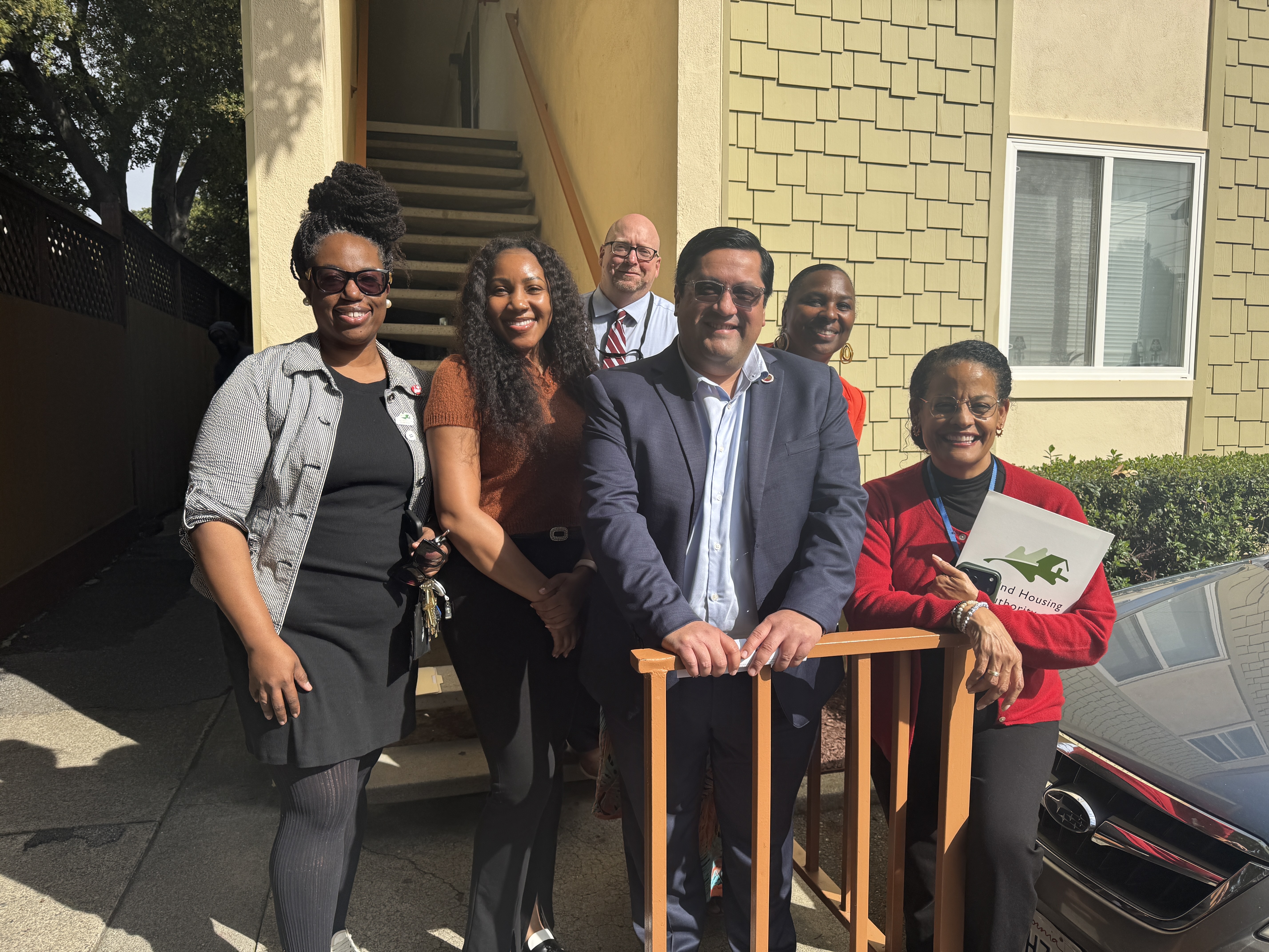 Sen. Jesse Arreguín and Oakland Housing Authority staff pose outside an affordable housing community in Oakland.