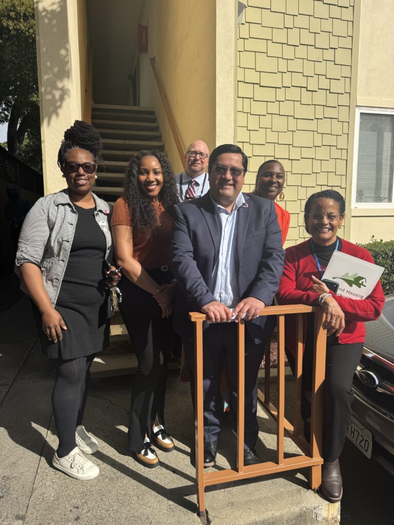 Sen. Jesse Arreguín and Oakland Housing Authority staff pose outside an affordable housing community in Oakland.