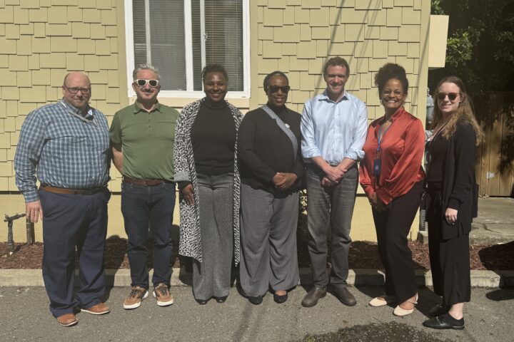 Oakland City Councilmember Zac Unger and Oakland Housing Authority staff pose outside an affordable housing property during a District 1 tour in Oakland