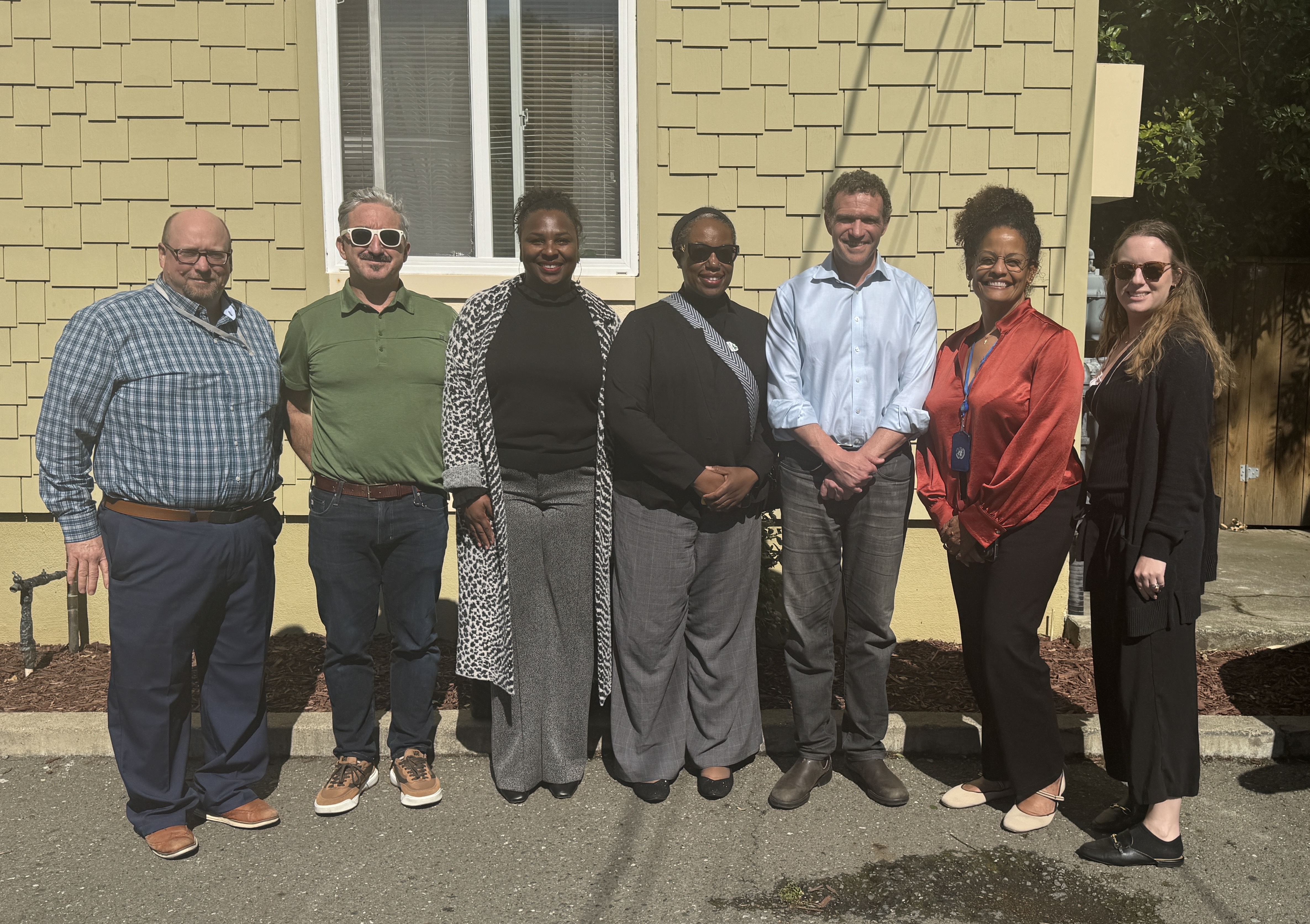 Oakland City Councilmember Zac Unger and Oakland Housing Authority staff pose outside an affordable housing property during a District 1 tour in Oakland