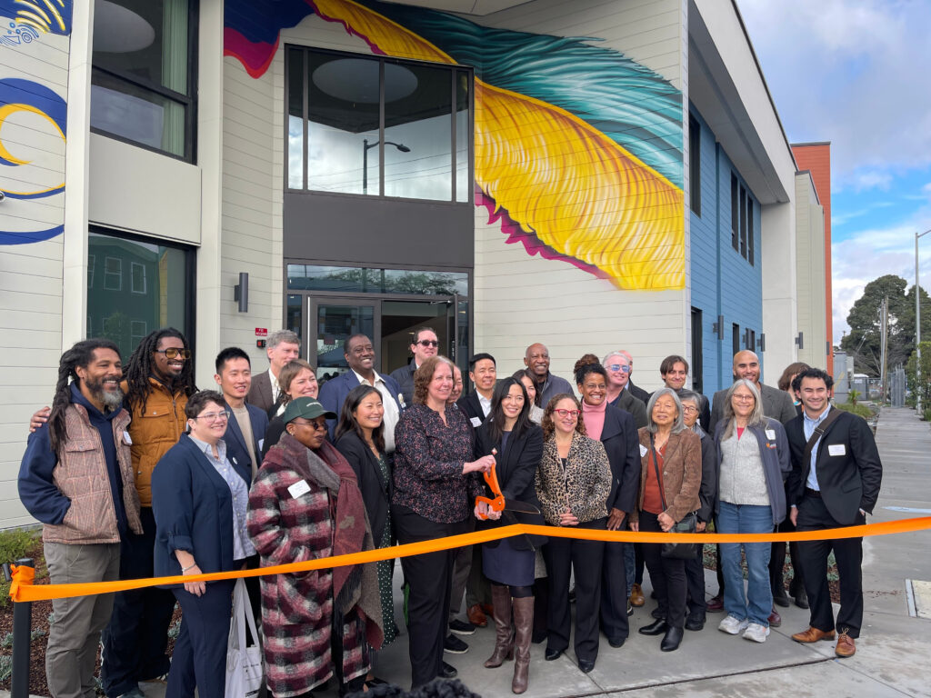 Community leaders and housing partners celebrate the ribbon cutting for The Phoenix affordable housing community in West Oakland.