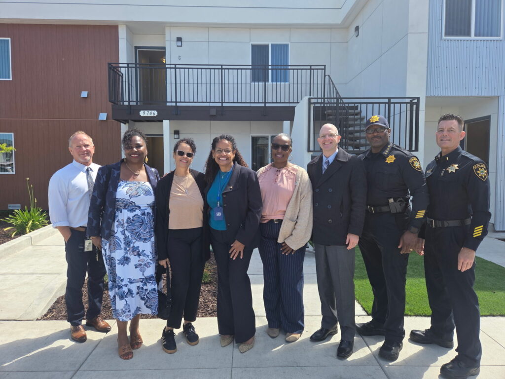 Oakland Housing Authority staff, community partners, and public safety representatives stand outside the rehabilitated 9746 Plymouth St. affordable housing property in East Oakland.
