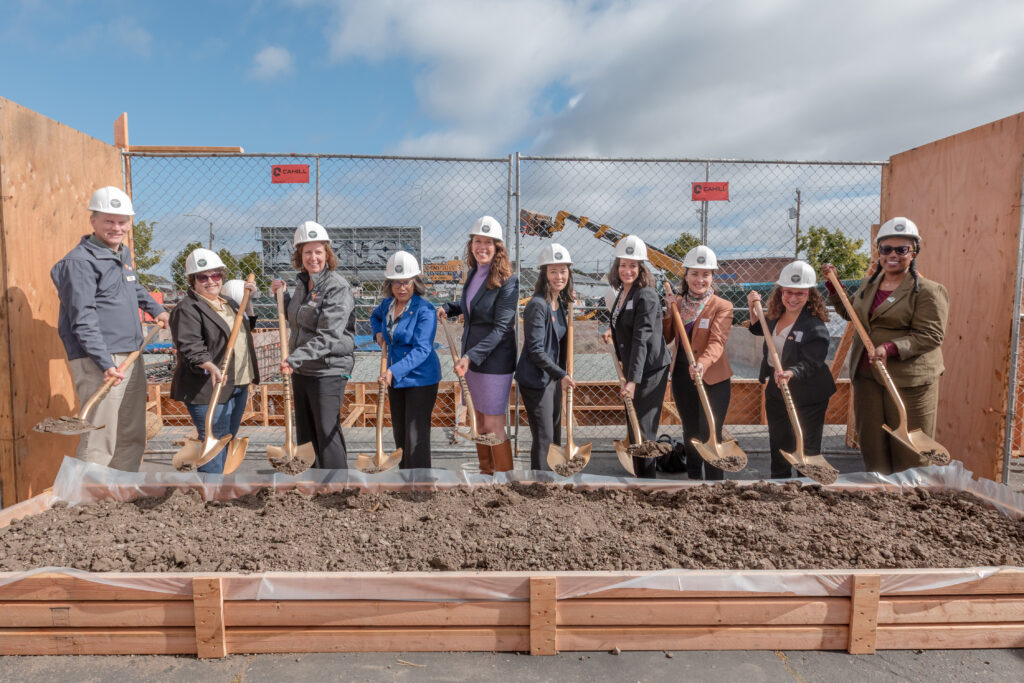 Project partners, elected officials, and community leaders stand with ceremonial shovels during the 34th & San Pablo groundbreaking ceremony in West Oakland.