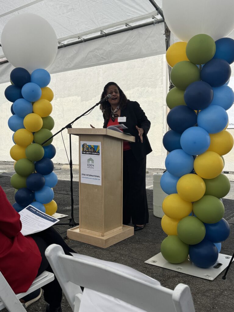 Oakland Housing Authority Executive Director Patricia Wells speaks at a podium during the 2700 International Blvd. groundbreaking ceremony in Oakland.